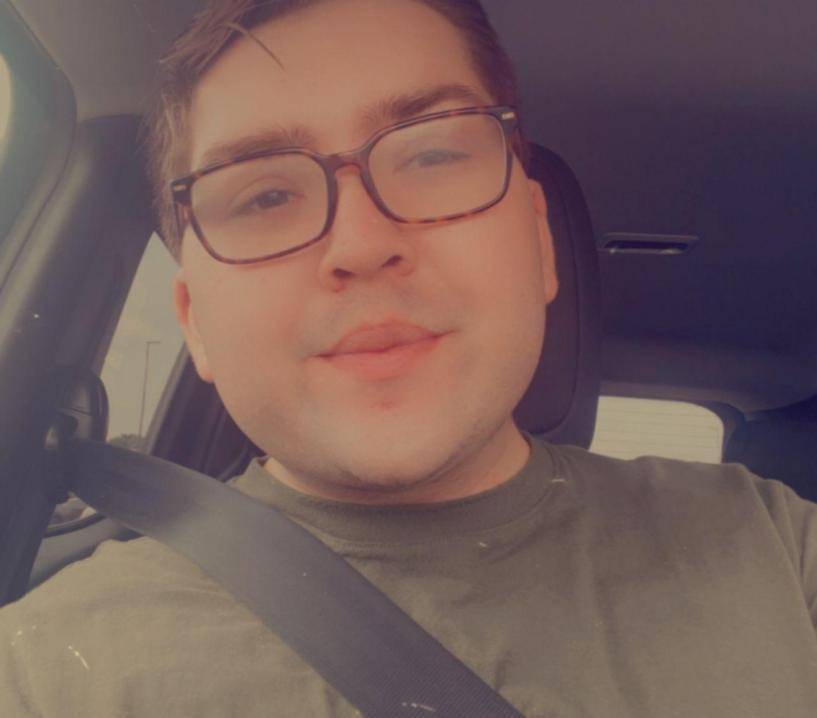 Boy sitting in car with seat belt, smiling at camera